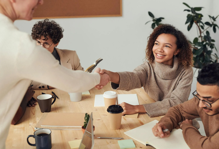 An image of digica llc team shaking hands with a client after a project approval - A satisfied client approving the project roadmap for a technology solution